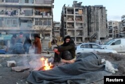 مردی که پس از زلزله خانه‌اش را تخلیه کردهبا آتش خود در هوای سرد گرم نگه می‌دارد. حلب، سوریه - ۱۹ بهمن ۱۴۰۱