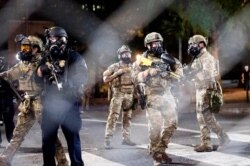 FILE - Federal agents disperse Black Lives Matter protesters near the Mark O. Hatfield United States Courthouse in Portland, Oregon, July 20, 2020.