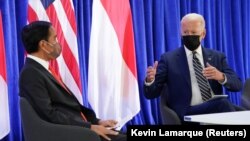 Presiden AS Joe Biden berbincang dengan Presiden Joko Widodo saat pertemuan bilateral pada Konferensi Perubahan Iklim PBB (COP26) di Glasgow, Skotlandia, Inggris, 1 November 2021. (Foto: REUTERS/Kevin Lamarque)