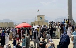 Hundreds of people gather outside the international airport in Kabul, Afghanistan, Aug. 17, 2021.