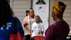 n this Friday, June 5, 2020 photo, Titilaya Thompson and her son Nehemiah talk with Dr. Tayarisha Batchelor, right, and Community School Director for The Village for Families and Children Trisila Tirado, left, in Hartford, Conn. (AP Photo/Jessica Hill)