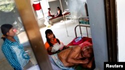 FILE - A malaria patient is comforted in the only hospital in Pailin, Cambodia.