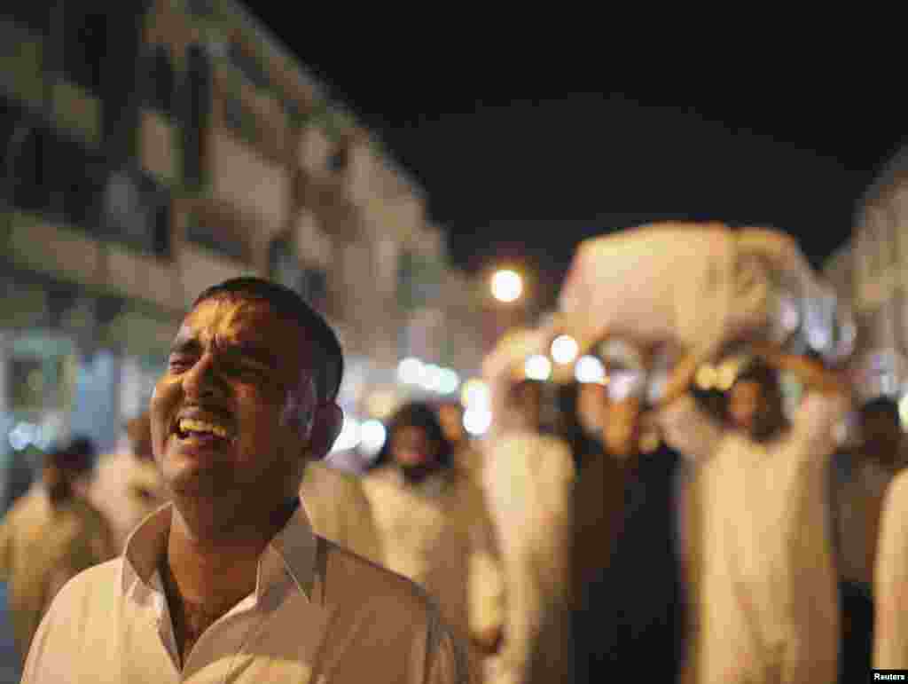 A man cries as mourners carry the coffin of an Iraqi soldier, who was killed in clashes with militants in Jurf al-Sakhar, during his funeral in Najaf, Iraq, July 5, 2014. 