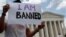 FILE - Mehrad Ansari of Iran holds a sign outside the U.S. Supreme Court after U.S. President Donald Trump's travel ban was upheld in Washington, June 26, 2018. 