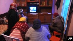 អ្នកស្រី​ Nour El Houda Hassani ម្តាយ​របស់​ Anis Amri អង្គុយ​ទី ពីរ​រាប់​ពី​ឆ្វេង​ដែល​​មាន​ពាក់​ក្រម៉ា​សនៅ​លើ​ក្បាលនិង​ឪពុក​របស់​គាត់លោក Mustapha Amri(ស្តាំ) កំពុង​មើល​ទូរទស្សន៍ជាមួយ​នឹង​អ្នក​ឯទៀត​បន្ទាប់​ពីកូន​ប្រុស​របស់​គាត់​បាន​ស្លាប់​នៅ Oueslatia ភាគ​កណ្តាល​ប្រទេស​ទុយ​នីស៊ីកាល​ពី​ថ្ងៃ​សុក្រ​ទី​២៣ ធ្នូ ២០១៦។