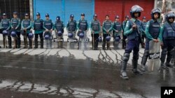 FILE - Bangladeshi policemen stand guard on a road near a court during a verdict against opposition leader and former Prime Minister Khaleda Zia in Dhaka, Bangladesh, Feb. 8, 2018.