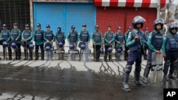 FILE - Bangladeshi policemen stand guard on a road near a court during a verdict against opposition leader and former Prime Minister Khaleda Zia in Dhaka, Bangladesh, Feb. 8, 2018.