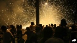 Armenian protesters run away from light grenades as they clash with police officers near the area around a police station in Yerevan, Armenia, Wednesday, July 20, 2016.