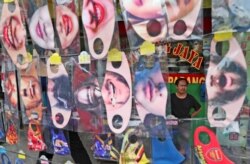 A man is seen through a display of fun face masks for sale at a roadside stall in Jakarta, Indonesia, July 16, 2020.