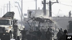 The debris of a bus attacked by Taliban fighters during a gunbattle, is removed from the site on the outskirts of Kabul, Afghanistan, 19 Dec 2010