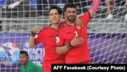 دو تن از بازیکنان تیم ملی فوتبال ساحلی افغانستان حین رقابت با مالیزیا