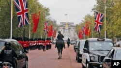 China's national flags are seen fixed on poles beside Union flags along The Mall near Buckingham Palace in London, Oct. 16, 2015, in anticipation of a state visit by Chinese President Xi Jinping and by his wife Peng Liyuan.