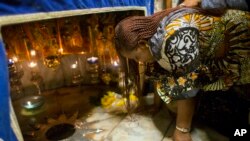 Una mujer cristiana ora en el Groto, debajo de la Iglesia de la Natividad, punto reconocido como el lugar exacto del nacimiento de Jesucristo en Belén. Las celebraciones de Navidad iniciaron en Belén con la participación de cristianos locales y peregrinos extranjeros. Foto AP