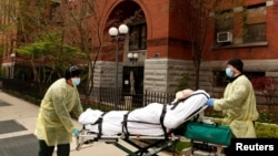 Para petugas medis membawa pasien lansia dari sebuah panti wreda di tengah pandemi virus corona (Covid-19) di Brooklyn, New York, 17 April 2020.