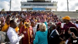 Democratic presidential candidate Hillary Clinton waves while visiting a homecoming game for Bethune-Cookman University Wildcats in Daytona Beach, Fla., Oct. 29, 2016, on her way to a rally.
