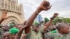 Colonel Malick Diaw, center, vice-president of the CNSP (National Committee for the Salvation of the People), gestures to supporters as Malian soldiers escort him through the Independence Square in Bamako, Aug. 21, 2020. 