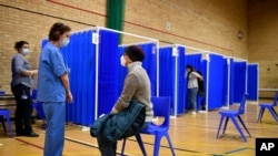Medical staff in booths prepare to administer the Pfizer-BioNTech COVID-19 vaccine at a vaccination centre in Cardiff, Wales, Dec. 8, 2020. 