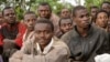 Suspected M23 rebel fighters sit in a group after surrendering to the Congolese army in Chanzo village in the Rutshuru territory near Goma, November 5, 2013.