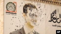 រូបភាព​របស់​ប្រធានាធិបតី​ស៊ីរី លោក Bashar Assad ដែលពោរពេញដោយ​គ្រាប់​កាំភ្លើង​ត្រូវ​បាន​គេ​ឃើញ​នៅ​លើ​មុខ​ការិយាល័យ​រដ្ឋាភិបាល​ខេត្ត​បន្ទាប់​ពី​ក្រុម​ប្រឆាំង​បាន​ចូល​កាន់កាប់​ក្រុង Hama ប្រទេស​ស៊ីរី នៅ​ថ្ងៃ​សុក្រ ទី ៦ ខែ​ធ្នូ ឆ្នាំ ២០២៤។