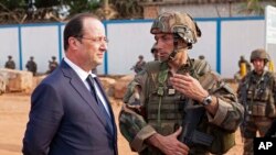 Le président français François Hollande discute avec un militaire de l'opération Sangaris lors de sa visite à Bangui, République centrafricaine, 28 février 2014. (AP Photo/Frederic Lafargue)