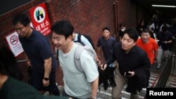 Pedestrians leave a subway station used as a shelter for emergency after a nationwide civil defense drill, which is being conducted for the first time in six years, to prepare in case of an air raid, in central Seoul, South Korea, Aug. 23, 2023