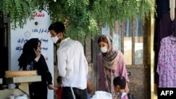 Mask-clad Iranians gather in a street in the capital Tehran, amid the ongoing novel coronavirus pandemic crisis, July 19, 2020.