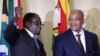 FILE - Zimbabwe's President Robert Mugabe (L) gestures as South Africa's President Jacob Zuma looks on at the end of a press briefing at the Union building in Pretoria, April 8, 2015.