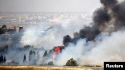 Smoke rises as a fire burns near the Quneitra transit point, as seen from the Israeli occupied Golan Heights, close to the ceasefire line between Israel and Syria, June 6, 2013.