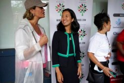 FILE - Boston mayoral candidates Annissa Essaibi George, left, and Michelle Wu, center, speak before the start of the Roxbury Unity Parade, in Boston's Roxbury neighborhood, July 18, 2021.