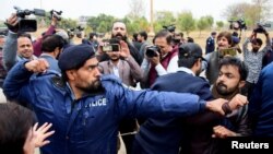 ইসলামাবাদে বিক্ষোভের সময় পুলিশ একজন সাংবাদিককে লক্ষ্য করে ঘুষি মারছে। ফটোঃ ২৮ জানুয়ারি, ২০২৫।