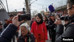FILE - Li Wenzu, wife of detained Chinese rights lawyer Wang Quanzhang, is followed by friends and media near a Supreme People's Court complaints office in Beijing, China, April 4, 2018. 