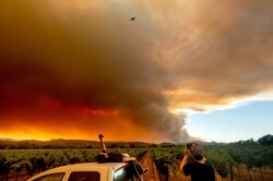 Thomas Henney, left, and Charles Chavira watch a plume spread over Healdsburg, Calif., as the LNU Lightning Complex fires burn, Aug. 20, 2020.