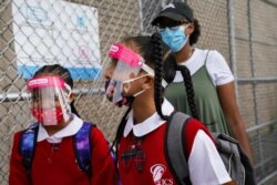 Students wear protective masks as they arrive for classes at the Immaculate Conception School while observing COVID-19 prevention protocols, Sept. 9, 2020, in The Bronx borough of New York.
