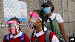 Students wear protective masks as they arrive for classes at the Immaculate Conception School while observing COVID-19 prevention protocols, Sept. 9, 2020, in The Bronx borough of New York.