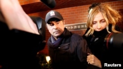FILE PHOTO: Former Nissan Motor Chairman Carlos Ghosn accompanied by his wife Carole Ghosn, arrives at his place of residence in Tokyo, Japan, March 8, 2019. REUTERS/Issei Kato/File Photo