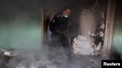 An Afghan police officer inspects the house of an Afghan member of parliament which was attacked by Taliban last night in Kabul, Afghanistan, Dec. 22, 2016. 