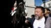 Artist Ai Weiwei passes a member of the Household Cavalry on duty outside Horse Guards Parade as he walks through central London, Sept. 17, 2015.