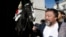 Artist Ai Weiwei passes a member of the Household Cavalry on duty outside Horse Guards Parade as he walks through central London, Sept. 17, 2015.