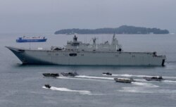 FILE - Royal Australian Navy HMAS Adelaide cruises alongside landing crafts with Philippine Marines and Australian troops as they conduct a joint Humanitarian Aid and Disaster Relief (HADR) exercise off Subic Bay.