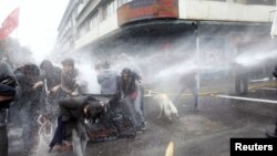 Para aktifis HAM yang berunjuk rasa menentang para pendukung mantan diktator Augusto Pinochet dan pemutaran perdana film dokumenter Pinochet, dibubarkan oleh polisi anti-huru hara dengan menggunakan semprotan air (10/6).