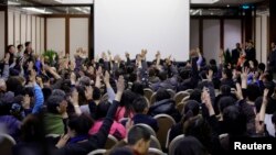 Para anggota keluarga penumpang pesawat Malaysia Airlines penerbangan MH370 melakukan pemunguntan suara untuk berbicara langsung pada wakil pemerintah Malaysia di Lido Hotel di Beijing (17/3). 