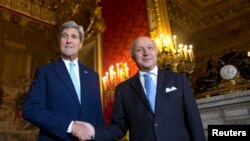 U.S. Secretary of State John Kerry (L) shakes hands with French Foreign Minister Laurent Fabius as he arrives at the Quai d'Orsay in Paris, Oct. 13, 2014.