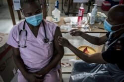 FILE - A doctor receives a Johnson & Johnson vaccine at the government hospital in Klerksdorp, South Africa, Feb. 18, 2021.
