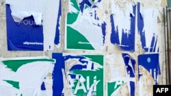 Des affiches de campagne déchirées du président gabonais déchu Ali Bongo Ondimba sont visibles sur un mur à Libreville le 31 août 2023.