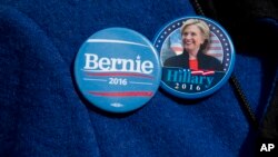 Seorang pendukung partai Demokrat mengenakan pin bergambar kandidat Capres AS Hillary Clinton dan logo kampanye Bernie Sanders (Foto: dok).