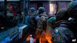 Sukarelawan dari batalyon Azov battalion menaiki sebuah bis menuju bagian timur Ukraina untuk bergabung melawan separatis pro-Rusia di Kyiv, 17 Januari 2015.