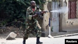 A soldier fires an AK-47 rifle during a protest against President Pierre Nkurunziza and his bid for a third term, in Bujumbura, Burundi, May 25, 2015.