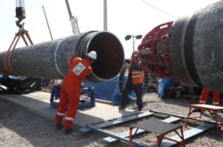 FILE - Workers are seen at a construction site of the Nord Stream 2 gas pipeline, near the town of Kingisepp, Leningrad region, Russia, June 5, 2019.