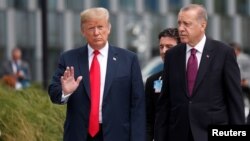 Presiden AS Donald Trump bersama Presiden Turki, Tayyip Erdogan berjalan bersama untuk menghadiri pembukaan KTT NATO di Brussels, Belgia, 11 Juli 2018. 