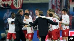 L'entraîneur de Leipzig, Ralph Hasenhuettl, à gauche, jubile avec son équipe après le coup de sifflet final du match de football de la Bundesliga allemande entre le RB Leipzig et le FC Schalke 04 à Leipzig, en Allemagne, 3 décembre 2016. 